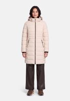 Frau trägt beige Daunenjacke mit Kapuze, dunkle Hosen und braune Sneakers.