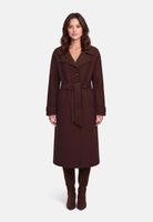 Elegante Frau im langen burgunderroten Trenchcoat mit Gürtel und hohen Stiefeln.