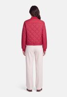 Rote Quilt-Jacke mit Kapuze, beige Hosen, Rückansicht einer Person.