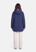 Frau trägt hellblaue Hooded-Jacke mit Reißverschluss, beige Hosen und flache Schuhe.